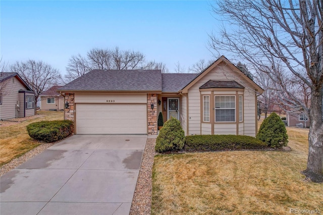 view of front of house with a front lawn, stone siding, an attached garage, and concrete driveway