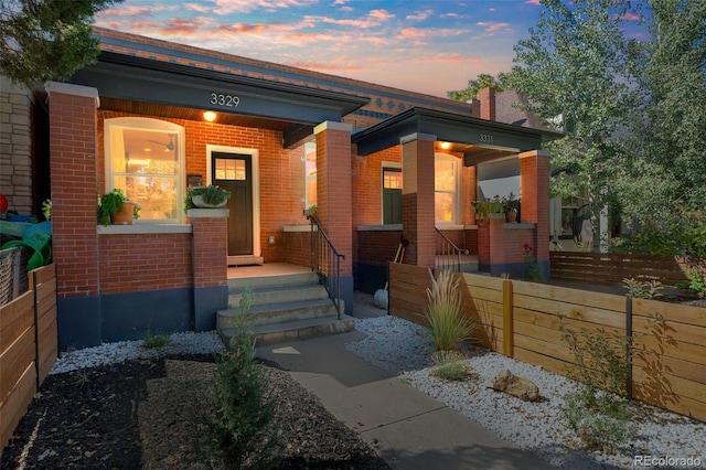 view of front of house featuring a porch and brick siding