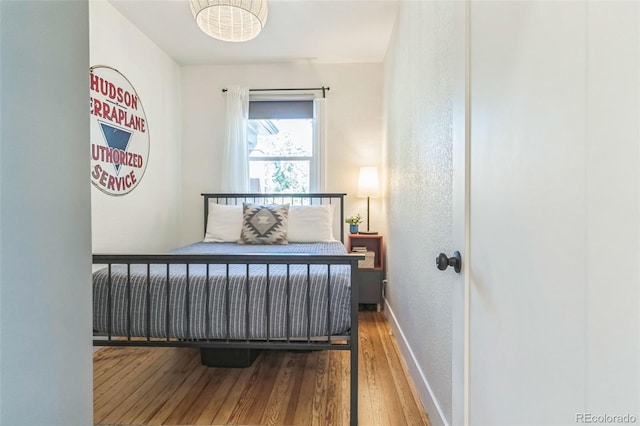 bedroom featuring baseboards and wood finished floors