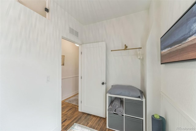 interior space featuring a wainscoted wall, visible vents, a decorative wall, and wood finished floors