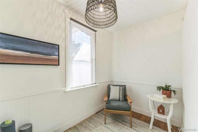 living area with wainscoting, baseboards, and wood finished floors