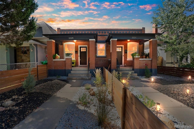 view of front facade featuring a fenced front yard and brick siding