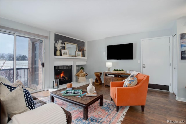 living room with a large fireplace and dark hardwood / wood-style flooring