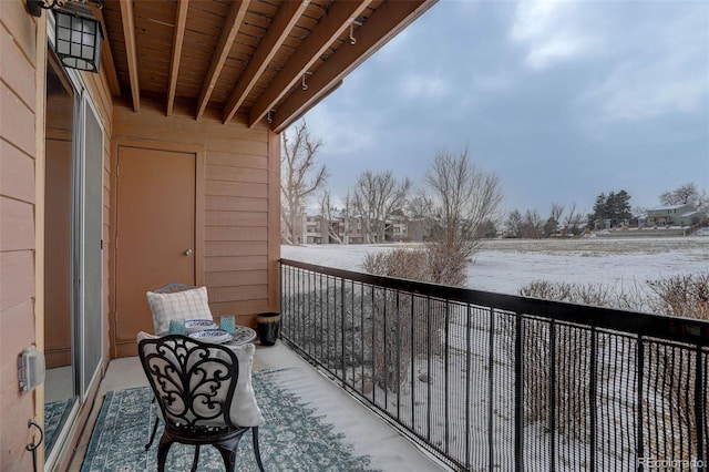 view of snow covered back of property