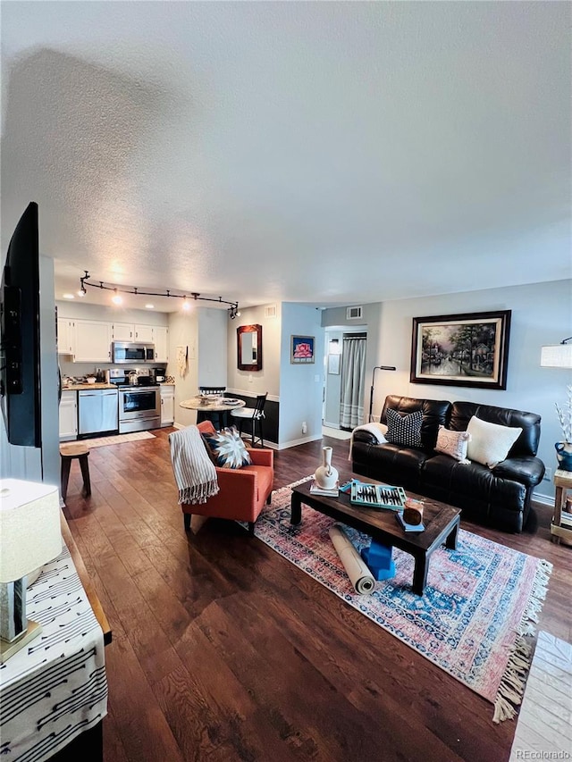 living room featuring dark hardwood / wood-style floors and a textured ceiling