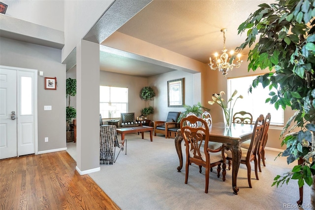 carpeted dining space featuring a chandelier