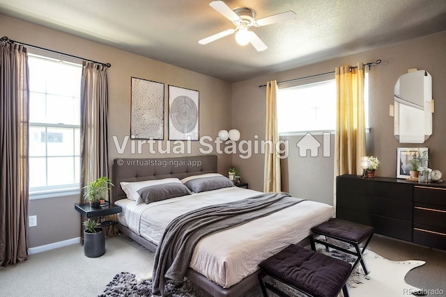 carpeted bedroom with ceiling fan and a textured ceiling