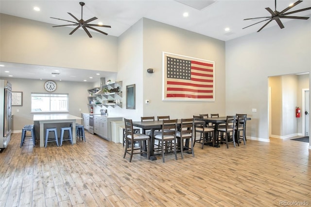 dining room with a high ceiling and light wood-type flooring