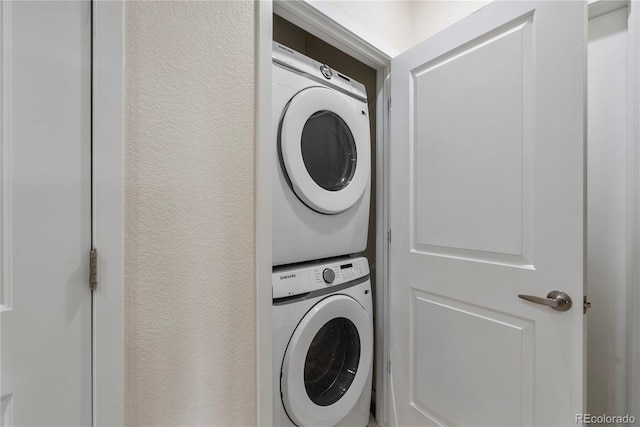 4100 Albion St Unit 424, Denver, CO 80216 - washroom with stacked washer / dryer and a textured wall