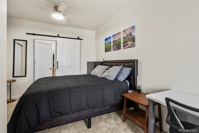 4100 Albion St Unit 424, Denver, CO 80216 - bedroom featuring carpet flooring, a barn door, and a ceiling fan
