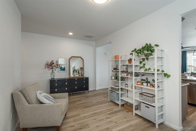 sitting room with hardwood / wood-style flooring and ceiling fan