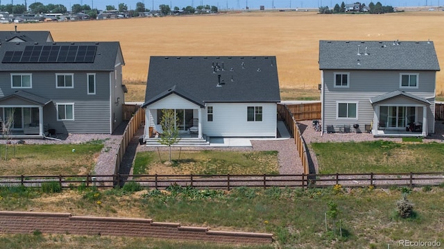 rear view of property featuring solar panels, a patio area, and a rural view