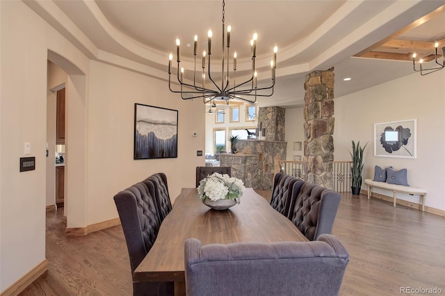 dining room with hardwood / wood-style flooring and a raised ceiling