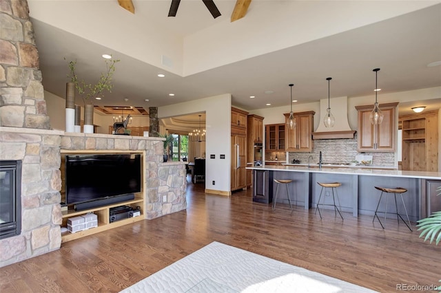 living room featuring a fireplace, ceiling fan with notable chandelier, and dark hardwood / wood-style floors