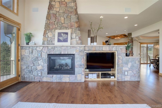 unfurnished living room with a stone fireplace and hardwood / wood-style flooring