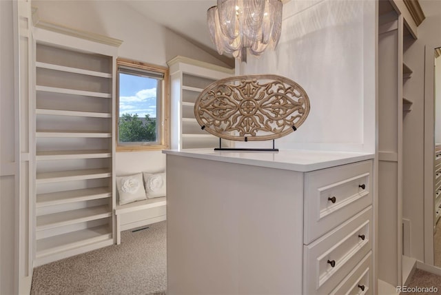 walk in closet featuring carpet floors and an inviting chandelier