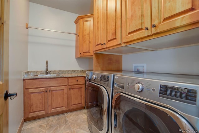 washroom featuring washer and clothes dryer, sink, and cabinets