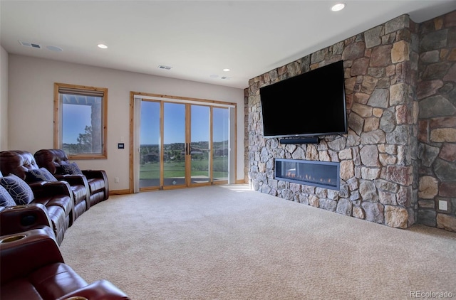 carpeted living room with a stone fireplace