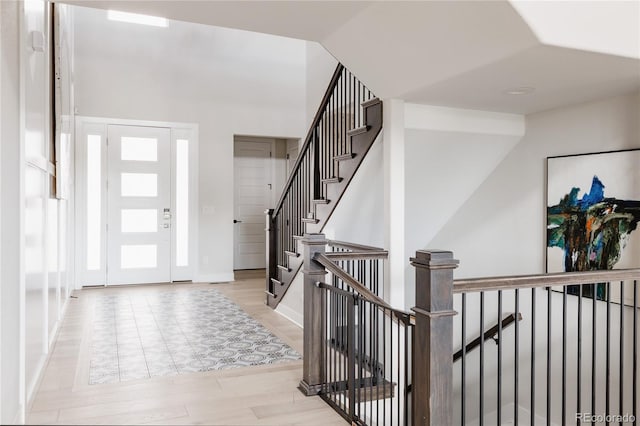 foyer entrance featuring baseboards and wood finished floors