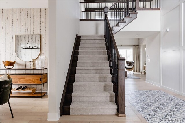 27608 E Ottawa Ave, Aurora, CO 80016 - stairs featuring wood finished floors, baseboards, and a towering ceiling