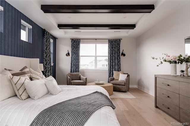 bedroom with baseboards, beamed ceiling, and light wood-type flooring