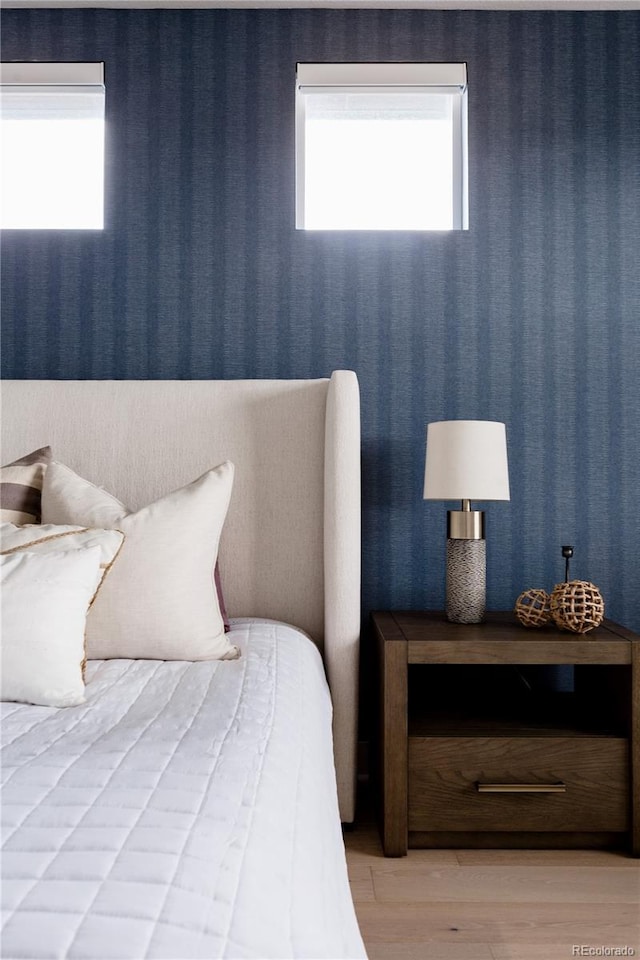 bedroom featuring wallpapered walls and light wood-style flooring