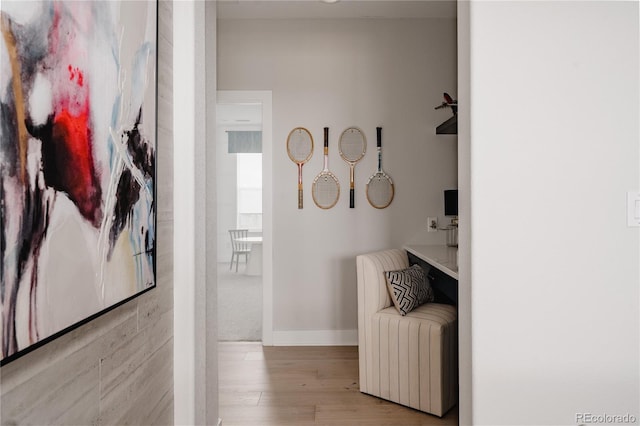 hall with baseboards and wood finished floors