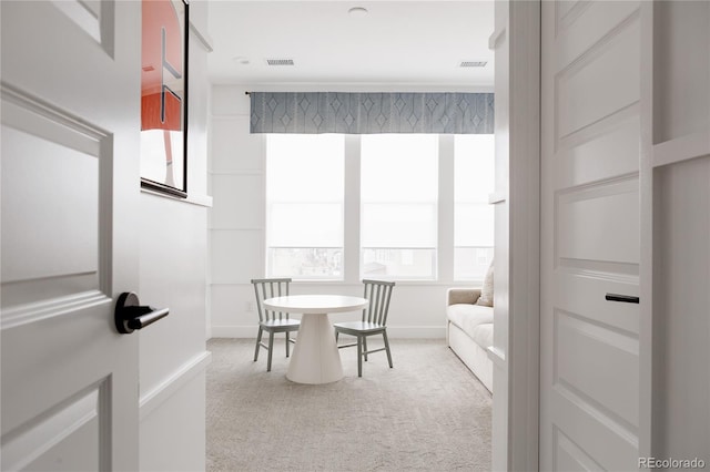 carpeted dining space with baseboards and visible vents