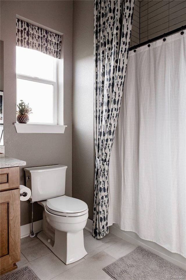 bathroom with tile patterned floors, baseboards, toilet, and shower / bath combination with curtain