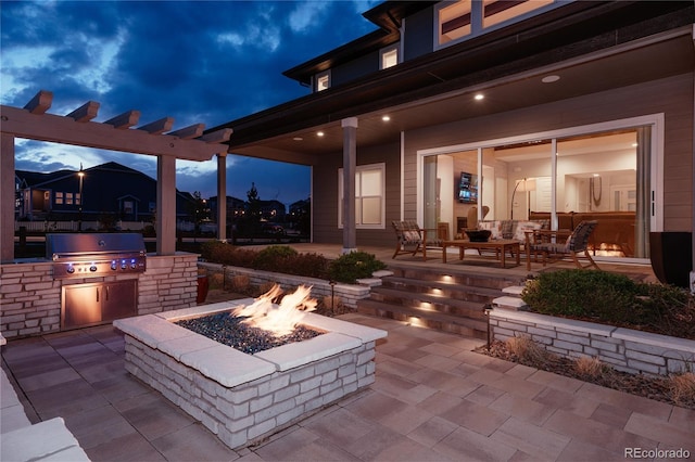 patio at twilight featuring an outdoor fire pit, grilling area, and area for grilling