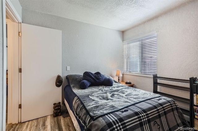 940 S Peoria St, Aurora, CO 80012 - bedroom featuring a textured wall, wood finished floors, and a textured ceiling