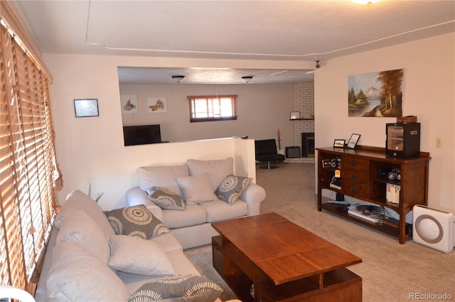 living area with a brick fireplace and carpet