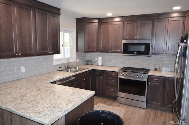 kitchen featuring dark brown cabinetry, stainless steel appliances, and a sink