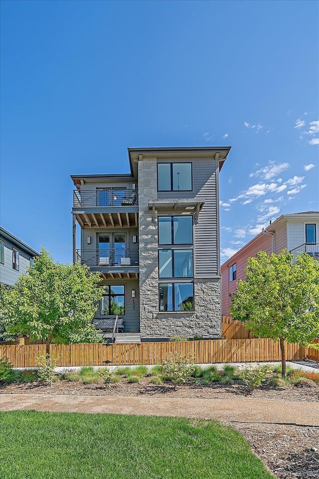 6047 N Nepal Ct, Aurora, CO 80019 - back of house featuring stone siding and a balcony