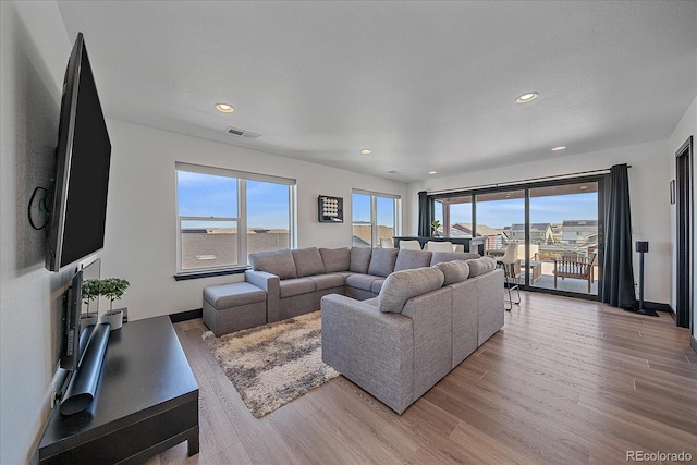 6047 N Nepal Ct, Aurora, CO 80019 - living area featuring light wood finished floors, healthy amount of natural light, and recessed lighting