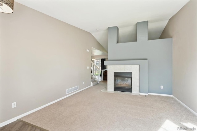 2905 E Yarrow Cir, Superior, CO 80027 - unfurnished living room with baseboards, lofted ceiling, carpet floors, a tile fireplace, and stairs