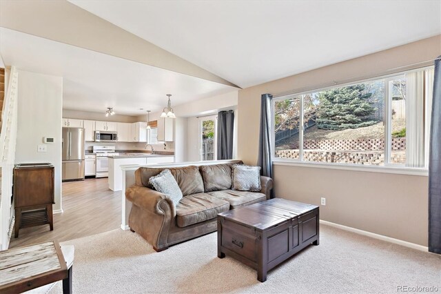 2905 E Yarrow Cir, Superior, CO 80027 - living area featuring lofted ceiling, light colored carpet, baseboards, and a chandelier