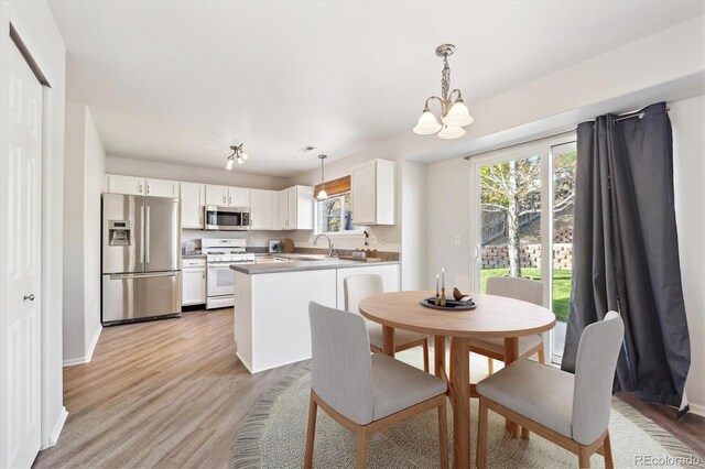 2905 E Yarrow Cir, Superior, CO 80027 - dining space with a chandelier, light wood-style flooring, and baseboards