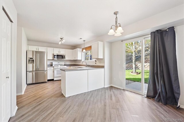 2905 E Yarrow Cir, Superior, CO 80027 - kitchen with stainless steel appliances, a chandelier, white cabinetry, light wood-type flooring, and baseboards