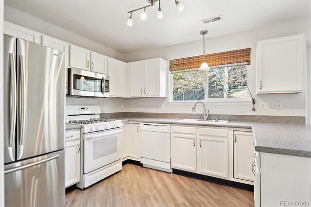 2905 E Yarrow Cir, Superior, CO 80027 - kitchen featuring appliances with stainless steel finishes, a sink, white cabinetry, and light wood finished floors