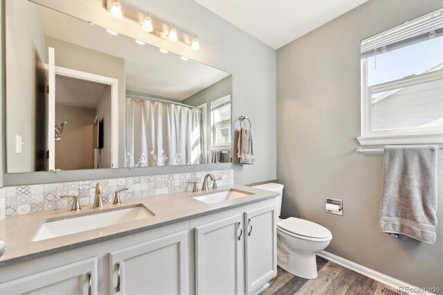 2905 E Yarrow Cir, Superior, CO 80027 - bathroom featuring toilet, wood finished floors, baseboards, double vanity, and a shower with shower curtain