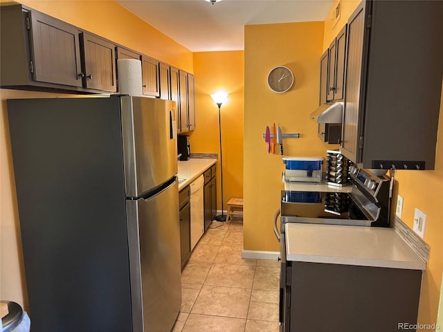 kitchen featuring light tile patterned floors, stainless steel appliances, and extractor fan