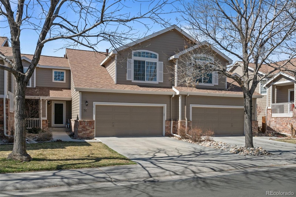 view of front of house with a garage, brick siding, and concrete driveway