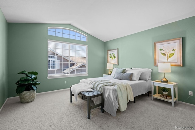 carpeted bedroom featuring baseboards and vaulted ceiling