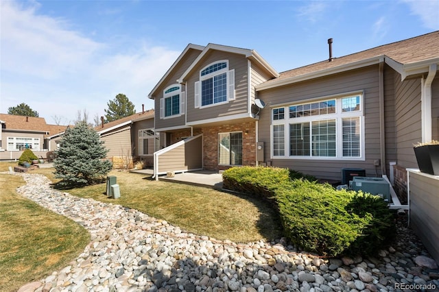 view of front of home featuring brick siding and a front lawn