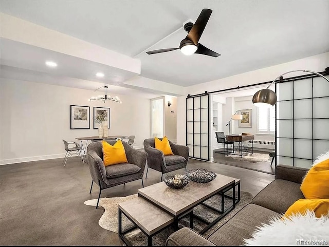 living room with vaulted ceiling, a barn door, and ceiling fan with notable chandelier