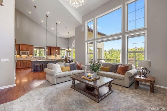 6299 Ellingwood Point Pl, Castle Rock, CO 80108 - living room featuring a chandelier, a high ceiling, and wood finished floors