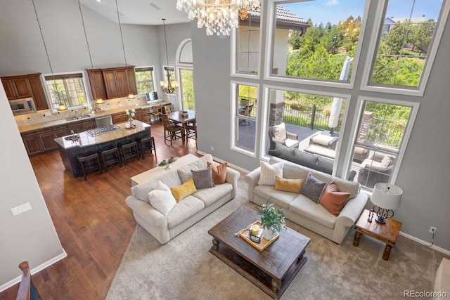 6299 Ellingwood Point Pl, Castle Rock, CO 80108 - living room with a high ceiling, a chandelier, and dark wood-style flooring