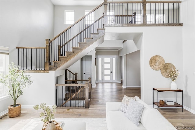 interior space with baseboards, a high ceiling, and wood finished floors