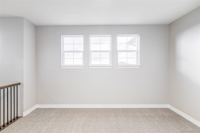 unfurnished room with carpet floors, baseboards, and a healthy amount of sunlight